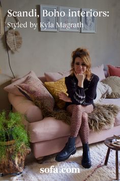 a woman sitting on top of a pink couch