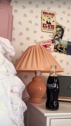 a lamp on a table next to a coca - cola bottle