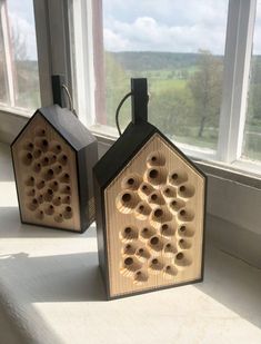 two bird houses sitting on top of a window sill