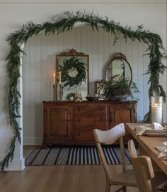 a dining room decorated with greenery and candles