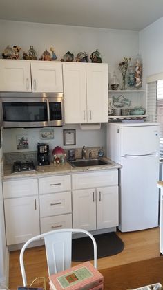 a kitchen with white cabinets and silver appliances