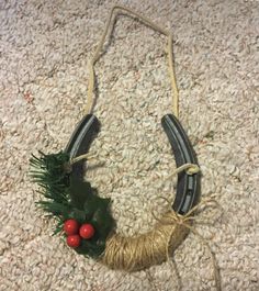 a christmas wreath made out of yarn and twine on the floor next to a pair of scissors