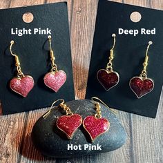 Show yourself or a friend some love with these adorable hypoallergenic sparkly glitter enamel heart earrings! These are great for formal or casual wear and are made of durable, brightly colored glittery enamel and metal alloy. Available in 3 colors: Deep red, hot pink and light pink Dangle length is approximately 1-inch. Heart charm is approximately 0.6-inch by 0.7-inch Hypoallergenic earring hooks Valentine's Day Gold Heart Enamel Earrings, Enamel Earrings With Heart Charm As Gift, Enamel Heart Charm Earrings As Gift, Gold Enamel Heart Earrings For Valentine's Day, Glitter Jewelry Gift, Glitter Jewelry For Gifts, Cute Glitter Jewelry Gift, Valentine's Day Gift Enamel Earrings, Sparkling Heart-shaped Earrings For Gift