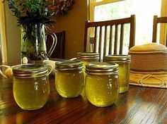 there are four jars on the table with flowers in them