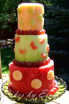 a three tiered cake with fruit on top