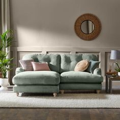 a blue couch in a living room next to a table with a mirror on it