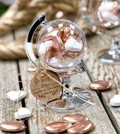 small glass vases filled with pink and white hearts sitting on top of a wooden table