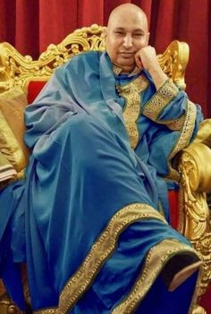 a man sitting on top of a golden chair