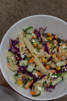 a white bowl filled with pasta and veggies