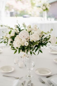 Elegant White and Green Wedding Flowers by Anthesis Co. Arbor, Centerpieces,Sweetheart table and more! Wedding located at Hayden Lake Country Club. White, greens and pops of yellow. Greenery garland. Simple White And Green Floral Centerpieces, Diy White Wedding Centerpieces, Wedding Arbor Behind Sweetheart Table, Whites And Greenery Wedding, Petals On Table Wedding, Classic Wedding Flower Arrangements, Wedding Reception Flowers Centerpieces Round Table, White And Green Centrepiece, White Peony Centerpiece Wedding