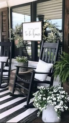 black and white striped rug on porch with rocking chairs, potted plants and welcome sign