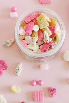 a glass bowl filled with pink and white heart shaped candies on top of a table