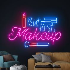 a neon sign that says, but first makeup on the wall next to a couch