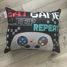 a pillow that is on the floor with some game controllers in front of it,