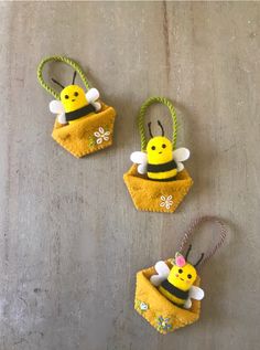 three little felt bee ornaments hanging from twine