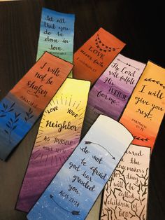 colorful bookmarks with writing on them sitting on top of a wooden table next to each other