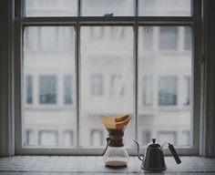 a coffee pot sitting on top of a counter next to a window