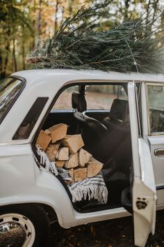 a white car with a pile of wood in the back seat