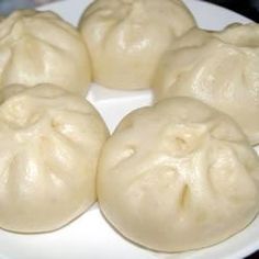 some dumplings are sitting on a white plate