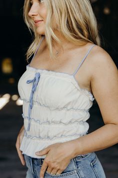 Head to the west(coast) in style with The Juliana Top. This cropped tank top features a charming cream color and playful ruffle details. The front bow adds a touch of cute cowgirl charm, perfect for a sunny summer day. Keasha is wearing size small paired with The Stacie Shorts Sunny Summer Day, Cute Cowgirl, Curvy Dress, Heritage Collection, Summer Day, Cropped Tank Top, Crop Tank, Bottoms Pants, West Coast