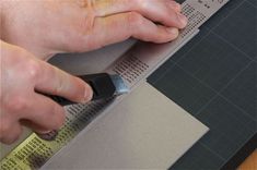 a person using a pair of scissors to cut out the pattern on a piece of paper