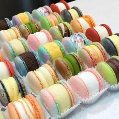 there are many different colored macaroons on the table