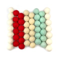 three different colors of wool balls on a white background