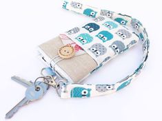 a small purse with an owl print on the front and key chain attached to it