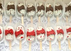 there are many desserts on sticks with red decorations