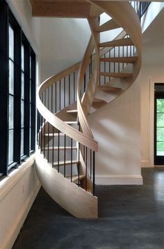 a wooden spiral staircase in an empty room