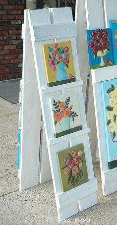 three eases with paintings on them sitting next to each other in front of a building