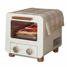 an open toaster oven with bacon cooking in it's door, on a white background