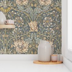 the wallpaper in this kitchen is painted with blue and yellow flowers, while two vases sit on a countertop