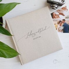 a wedding album with two photos and a camera next to it on a white table