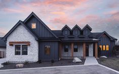 a house that is sitting in the middle of a lot with a sunset behind it