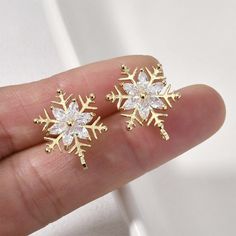 a pair of snowflake earrings is shown in the palm of someone's hand