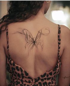 a woman with a butterfly tattoo on her back