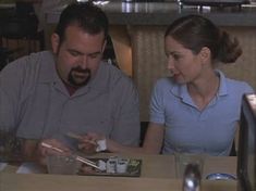 a man and woman sitting at a table eating sushi