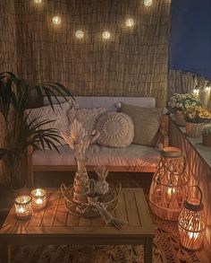 an outdoor living area with wicker walls and lights on the ceiling, including candles