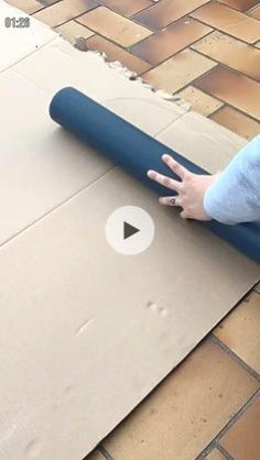 a person is rolling up a yoga mat on the ground