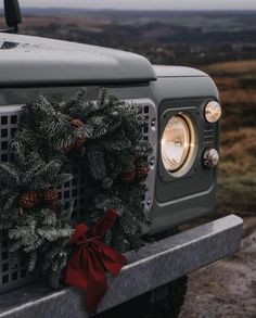 a christmas wreath on the hood of a jeep