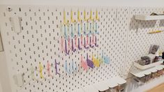 the wall is decorated with many different colored letters and numbers on white pegboards, along with several other crafting supplies