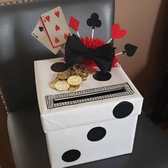 a white box with black polka dots and a bow tie on it, sitting in front of a chair