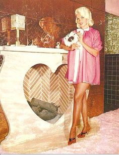 a woman standing in front of a fireplace holding a cat