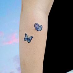 two blue butterflies on the arm