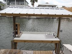 a boat dock with a sink under a metal roof