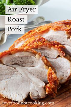 an air fryer roast pork on a cutting board with broccoli in the background