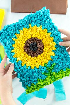 someone is holding a crocheted sunflower in their hands