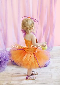 An orange colored tutu made onto an matching tutu top that is embellished with a large plastic eye, felt fangs, and purple tentacles is perfect outfit for Halloween pictures and costumes! Headband included! Great for baby showers, photo props, portraits, special occasions, and birthdays! Other monster costumes sold here: https://www.etsy.com/shop/OnceUponATimeTuTus?ref=seller-platform-mcnav&search_query=monster+alien+tutu Sizes: (Length of tutu portion only) Newborn - 6 Months Length - 6 inc Halloween Tulle Tutu Dress For Dress-up, Halloween Tulle Tutu Dress, Fitted Tutu Dress For Halloween Dress-up, Orange Tulle Tutu Dress For Party, Orange Tulle Tutu Party Dress, Cute Tutu Dress For Halloween Costume, Cute Halloween Tulle Tutu Dress, Cute Halloween Costume Tutu Dress, Purple Tentacles