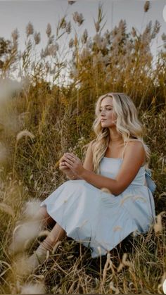 a woman is sitting in the tall grass